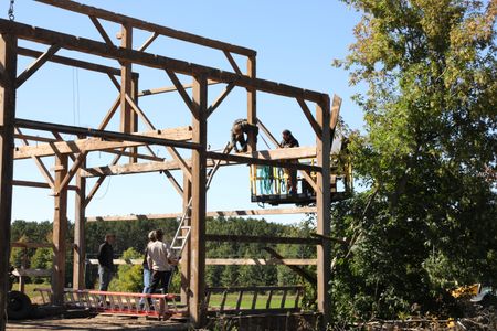 Seth Doble, William Klein, and Scott Brady hold up a ladder for Ben Reinhold and Charles Pol, as they take down beams from the old barn. (National Geographic)