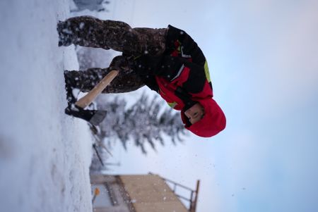 Wade Kelly cuts through the frozen ground with his axe. (BBC Studios Reality Productions, LLC/Ashton Hurlburt)