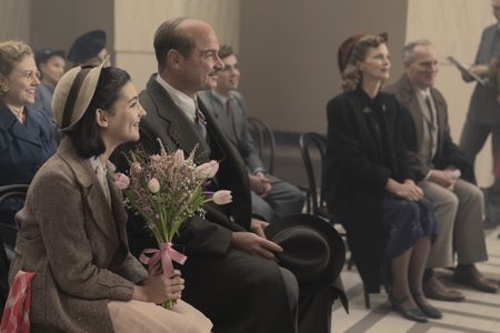 A SMALL LIGHT - Friends and family gather for Miep and Jan's wedding as seen in A SMALL LIGHT. (From left: Sally Messham as Bep, Billie Boullet as Anne Frank, Liev Schreiber as Otto Frank, Laurie Kynaston as Cas, Cosima Shaw as Genofeva, and Brian Caspe as Laurens). (Credit: National Geographic for Disney/Dusan Martincek)