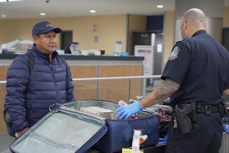 CBP Supervisory Officer Pacheco questions a passenger while going through their belongings in Atlanta, Ga. (National Geographic)