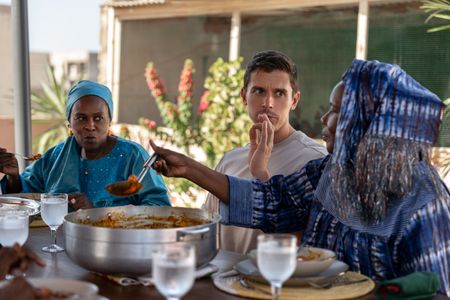 Moi Ndeye Fatou, Antoni Porowski and Marie Diop eat Soupe Kanja on a rooftop. (National Geographic/John Wendle)