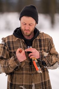 Johnny Rolfe cuts himself while he sets a line for burbot underneath the frozen ice. (BBC Studios Reality Productions/Patrick Henderson)