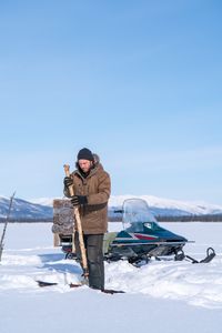 Johnny Rolfe sets fishing lines underneath the ice.(BBC Studios Reality Productions/Patrick Henderson)