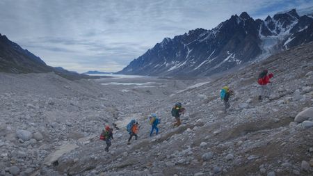 The full team hikes up a rocky landscape. (photo credit: National Geographic/Pablo Durana)
