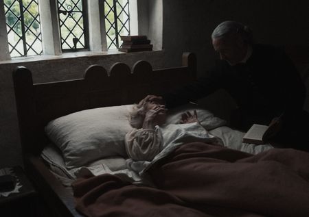 Reverend Sinclair prays over a bedridden Ann Haltridge. (Dash Productions Services LTD/Antoan Ivanov)