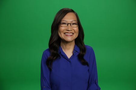 Helen Hong smiling and sitting Infront of a green screen. (National Geographic/Robert Toth)