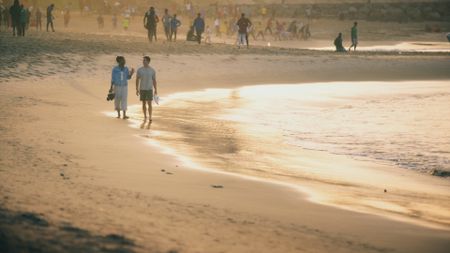 Issa Rae and Antoni Porowski walk along the beach in Dakar. (National Geographic)