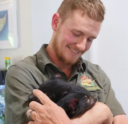 Tyler holding two tasmanian devil babies. (Big Wave Productions)