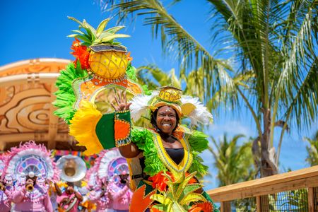 A performer waves while participating in a presentation for guests on Lookout Cay at Lighthouse Point, The Bahamas. (Disney/Steven Diaz)