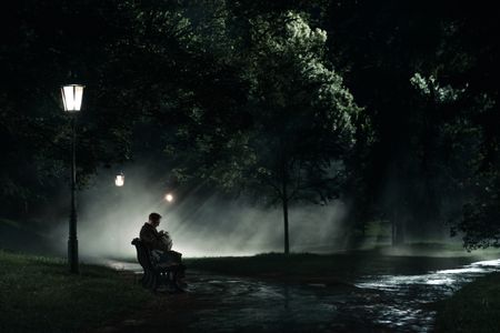A SMALL LIGHT - Jan Gies, played by Joe Cole, waits on a park bench in the night, as seen in A SMALL LIGHT. (Credit: National Geographic for Disney/Dusan Martincek)