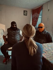 Mariana van Zeller interviews "Señor T" and "Amarillo," members of a gang involved in the fake pill trade, at a safe house in Mexico City. (National Geographic for Disney)