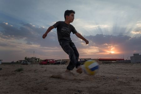 A boy plays football at dusk in Sinjar, Iraq. (Sean Sutton)