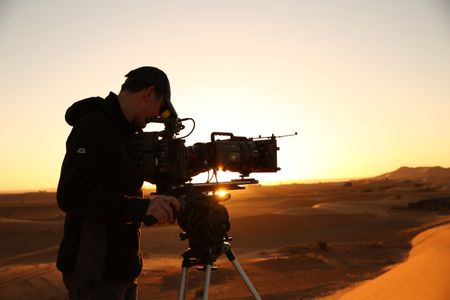 Lindsay McCrae films the Moroccan desert at sunrise. (National Geographic for Disney/Jonjo Harrington)