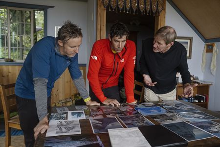 (From left to right): Tommy Caldwell and Alex Honnold listening to Dieter Klose discussing the Devil's Thumb whilst looking at a variety of images of the mountain. (National Geographic/Ryan Valasek)