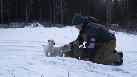 Jody Potts-Joseph plays with puppies. (National Geographic/Wayne Shockey)