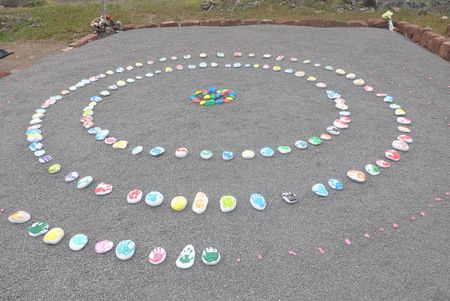 Hand printed pebble stones are placed on the gravesite at St. Helena. MYSTERIOUS ISLANDS takes viewers on an unforgettable adventure to explore the most extraordinary and enigmatic islands on the planet. (Credit: VINCE)