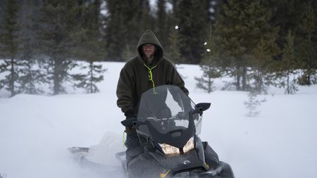 Jessie Holmes breaks trail with his snowmobile while traveling near his cabin. (BBC Studios Reality Productions, LLC/JR Masters)