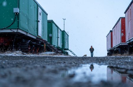 Sue Aikens checks Kavik River Camp with a fox companion. (BBC Studios Reality Productions/Jayce Kolinski)