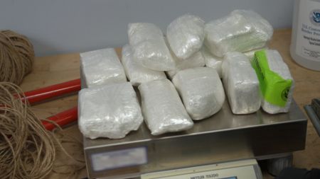 Multiple packages of cocaine are weighed on a scale after they were found smuggled in a shipment at the JFK International Airport in New York. (National Geographic)