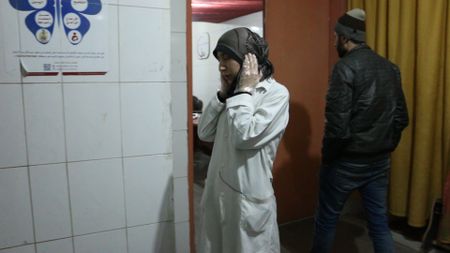 Al Ghouta, Syria - Dr Amani covers her ears during nearby bombings. (National Geographic)