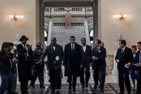 Malcolm X, played by Aaron Pierre, is followed by reporters as he enters the US Senate in GENIUS: MLK/X. (National Geographic/Richard DuCree)
