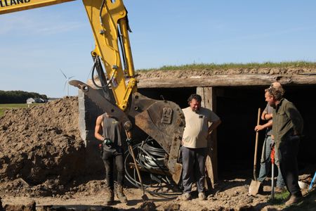 Scott Brady, Charles Pol, Seth Doble, and Ben Reinhold continue to dig out the sheep hut's floor to add concrete and move the water pipe which will provide better drainage. (National Geographic)