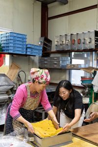 Yoon Hee Lee and Awkwafina make tteok, a sweet cake made from rice flour. (Credit: National Geographic/Seong Joon Cho)