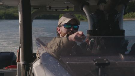 CBP AMO Agent Squires points ahead to an oncoming vessel to alert his crew near Mayaguez, P.R. (Lucky 8 TV/Paul Taggart)