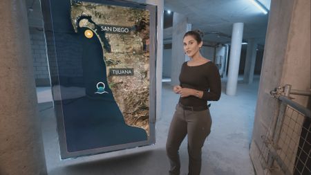 Dr. Diva Amon standing in the shark lab studio next to a GFX map of San Diego. (National Geographic)