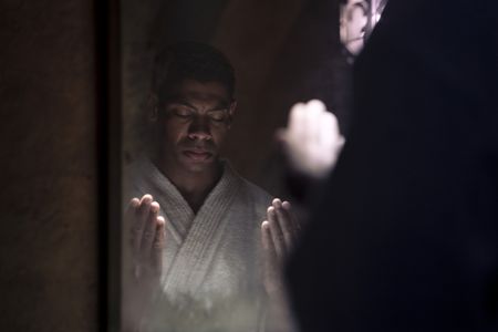 Malcolm X, played by Aaron Pierre, cleans and purges himself before praying in GENIUS: MLK/X. (National Geographic/Richard DuCree)