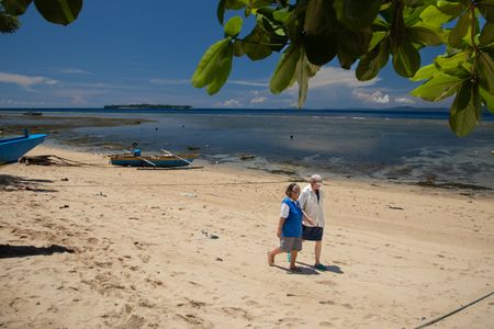 Bunaken resident, Tante Ita, left, and Dr. Crissy Huffard discussing Algae octopus (Abdopus aculeatus) as they walk along the shores of Bunaken Island.(photo credit: National Geographic/Annabel Robinson)