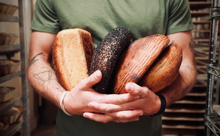 Baker Josey Baker holds an assortment of his naturally leavened loaves in his in San Francisco bakery, The Mill. Since it opened in 2012, Josey's bakery has become a popular destination in the city. (National Geographic/Ryan Rothmaier)