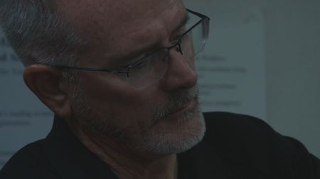 A CBP AMO Agent is pictured in close-up portrait as he looks at a large amount of drugs they just found  in Mayag¸ez, P.R.. (Lucky 8 TV/Paul Taggart)