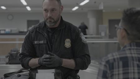 CBP Officer Mccants looks through a passenger's belongings in search of contraband or agriculture violations in Atlanta. (National Geographic)