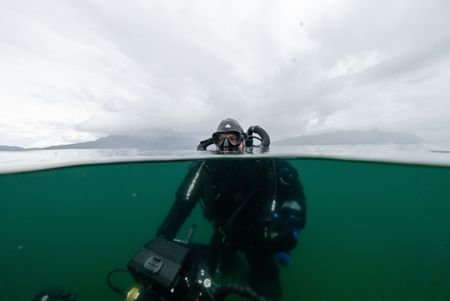 Underwater Camera Operator Florian Graner searching above the surface for the dorsal fins of salmon sharks. (National Geographic for Disney/Kayvon Malek)