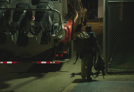 A CBP agent walka on the side of a tow truck towing a boat in Fajardo, P.R. (Lucky 8 TV/Ivan Leon)