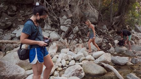 Producer Elena Gaby watches the monitor as cinematographer Nick Kraus films Angel Collinson walking over rocks.  (National Geographic/Galen Murray)