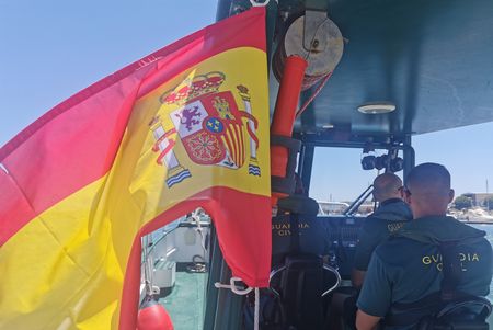 Civil Guards sail with a waving Spanish flag in Huelva, Andalusia, Spain. (National Geographic/Antonio Javier López Castillo )