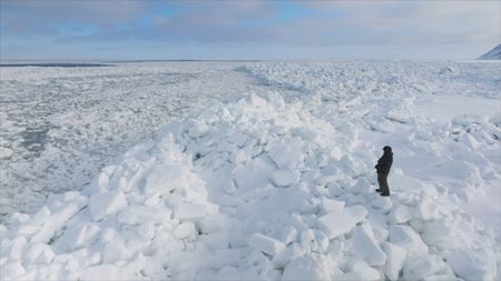 Daniel Apassingok looks out into the frozen Bering Sea, looking for walrus. (National Geographic)