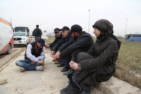 Al Ghouta, Syria - Dr. Amani (R) waits with others during the evacuation. (National Geographic)