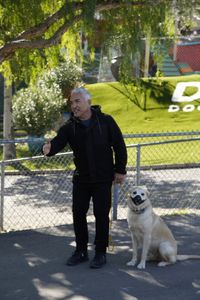 Cesar with Sansa on leash wearing a muzzle. (National Geographic)