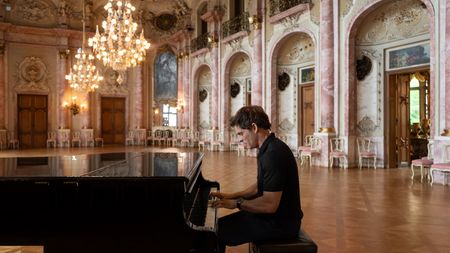 James Marsden plays the piano in the ballroom at Schloss Bückeburg. (National Geographic/Rebecca Eishow)