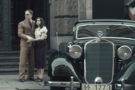 A SMALL LIGHT - Jan and Miep Gies, played by Joe Cole and Bel Powley, outside the Gestapo Headquarters as seen in A SMALL LIGHT. (Credit: National Geographic for Disney/Dusan Martincek)