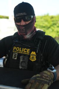 A CBP Agent's face is wrapped in protective gear on a water vessel in Mayaguez, P.R. (Lucky 8 TV/Paul Taggart)