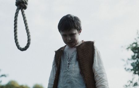 A young boy stands before a noose, looking at the ground. (Dash Productions Services LTD/Antoan Ivanov)