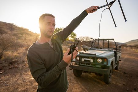 Giles Clark searches for Elektra the pangolin using radio telemetry. (National Geographic/Mark Challender)