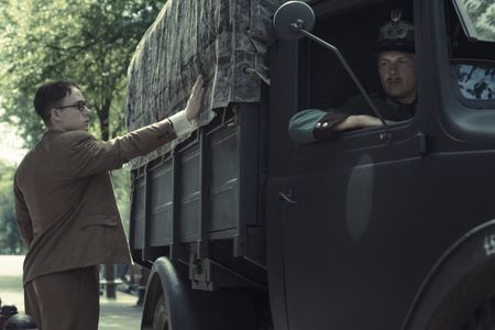 A SMALL LIGHT - Jan Gies, played by Joe Cole, touches the side of a German truck carrying the Frank family as seen in A SMALL LIGHT. (Credit: National Geographic for Disney/Dusan Martincek)