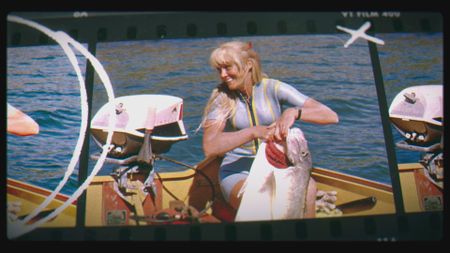 Valerie Taylor in boat holding up large fish, 1965.  (photo credit: Ron & Valerie Taylor)