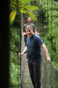 Puerto Rico - Gordon Ramsay (foreground) and his local guide, Jorge (background), cross a footbridge in a rainy forest in Puerto Rico. (Credit: National Geographic/Joelly Rodríguez)