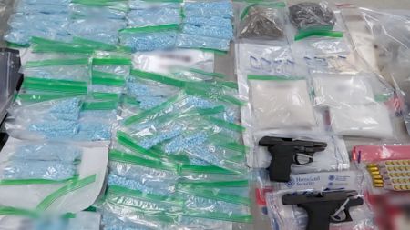 Multiple items of contraband (narcotics, firearms, etc.) were placed on an inspection table after they were apprehended by HSI during a conducted operation in Miami, Fla. (National Geographic)